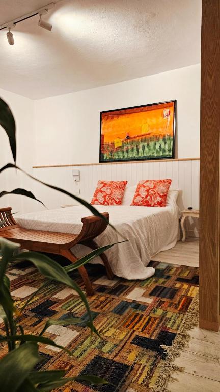 a bedroom with a bed and a painting on the wall at The loft - A charming sanctuary in Rivière Noire