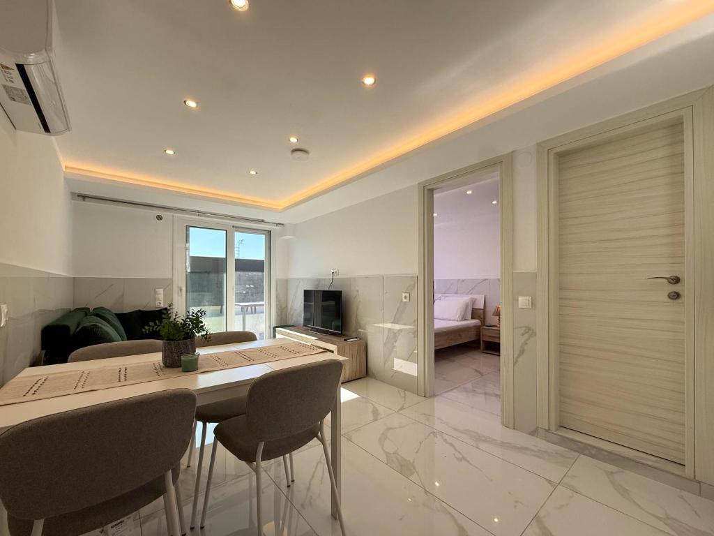 a kitchen and living room with a table and chairs at MELISSA Suites By SDR in Paralia Katerinis