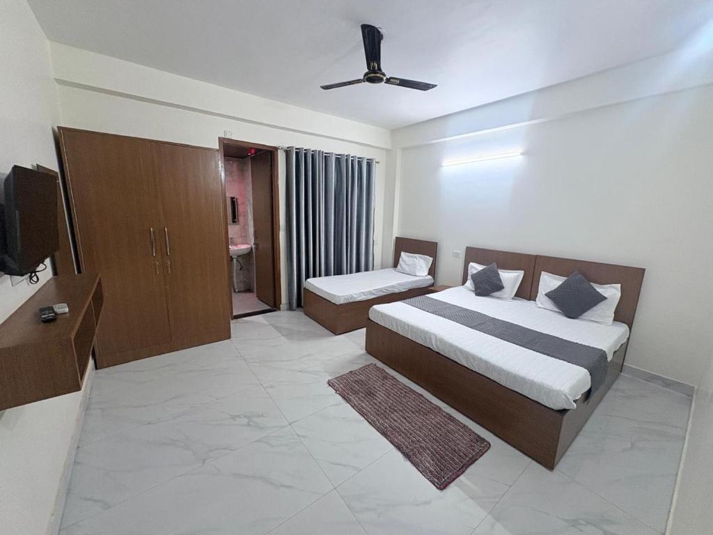a bedroom with two beds and a television in it at Hotel 69 in Gurgaon