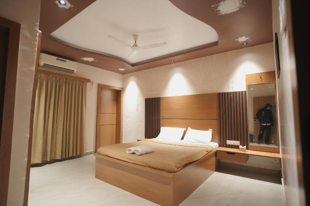 a bedroom with a large bed with a ceiling at Greenland Resort in Silvassa