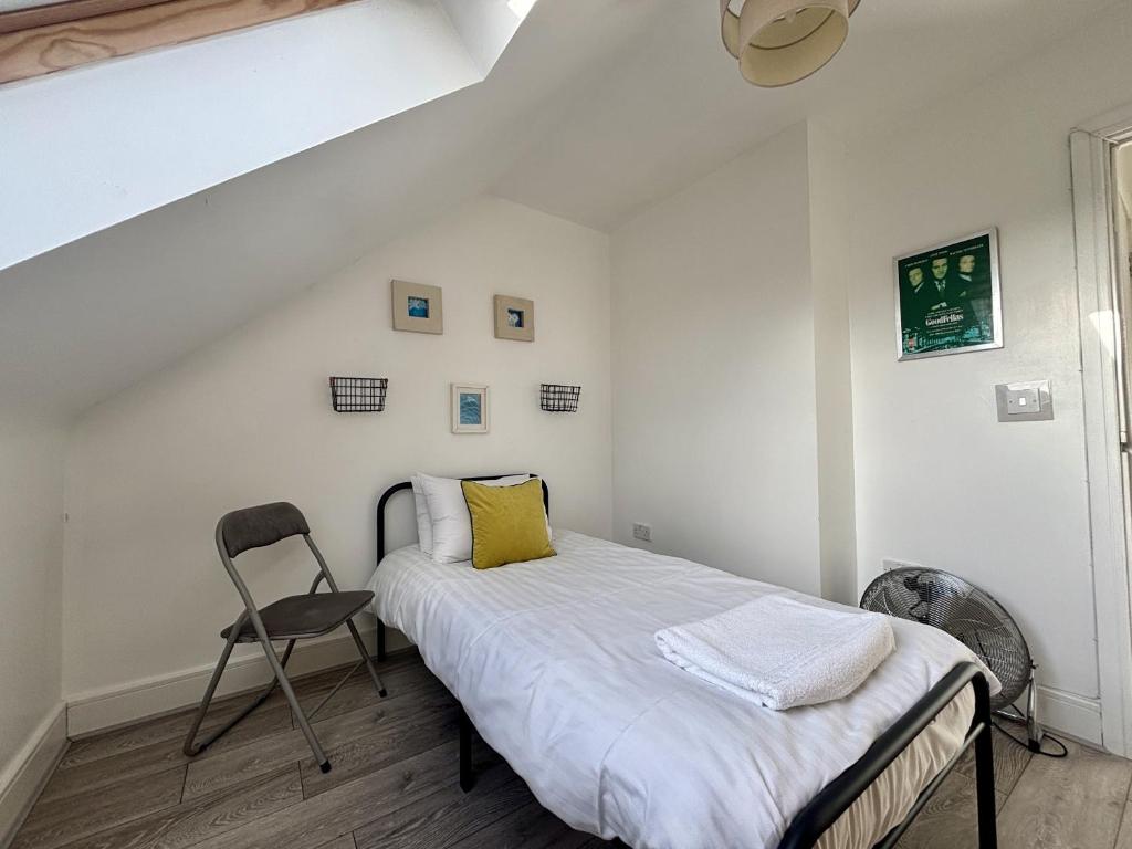 a small bedroom with a bed and a chair at Egham Modern Two Bedroom Apartment in Egham