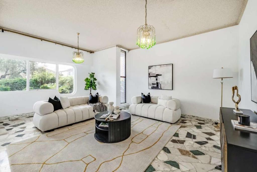 a living room with two white couches and a table at Comfortable House-shared accommodation in Bankstown