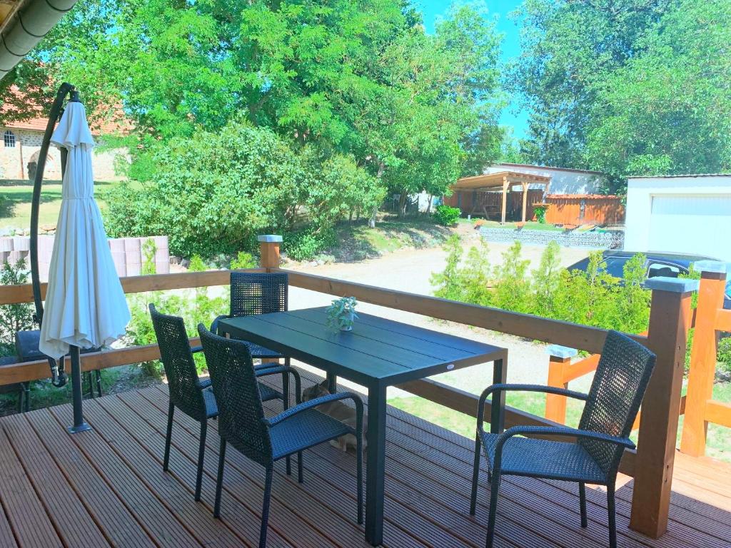 a table and chairs on a deck with an umbrella at Ferienwohnung Perle im Grünen - Urlaub an der Müritz in Federow