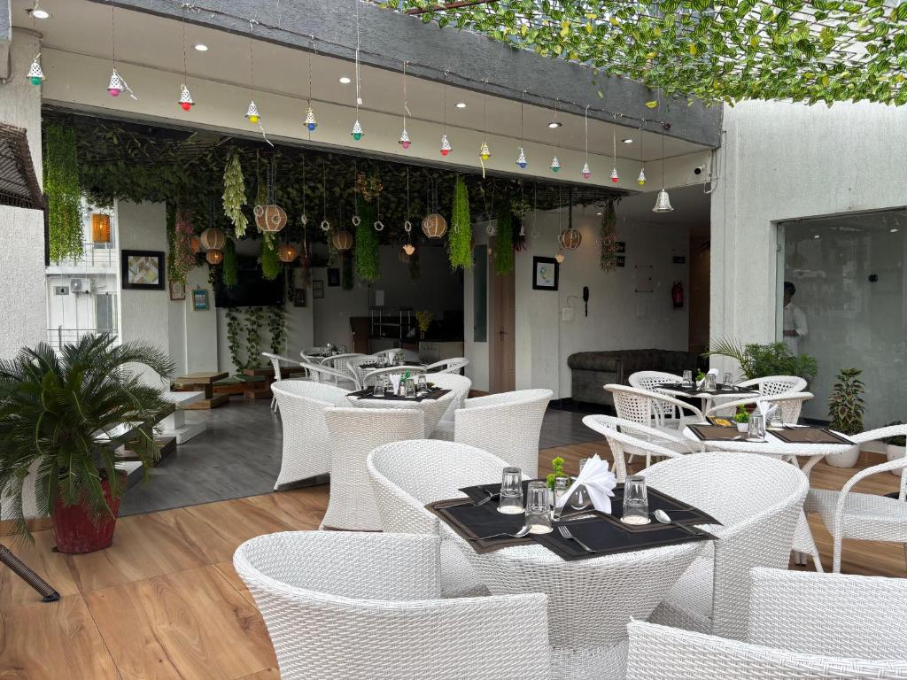 a restaurant with white tables and white chairs at Hotel JP Hills Rishikesh in Rishīkesh