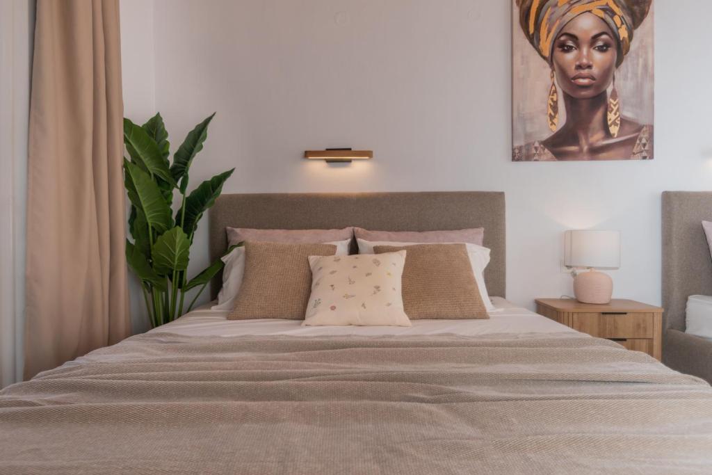 a bedroom with a bed with a portrait of a woman at Theodora Studios Best Location In Laganas Next To The Party Area in Laganas