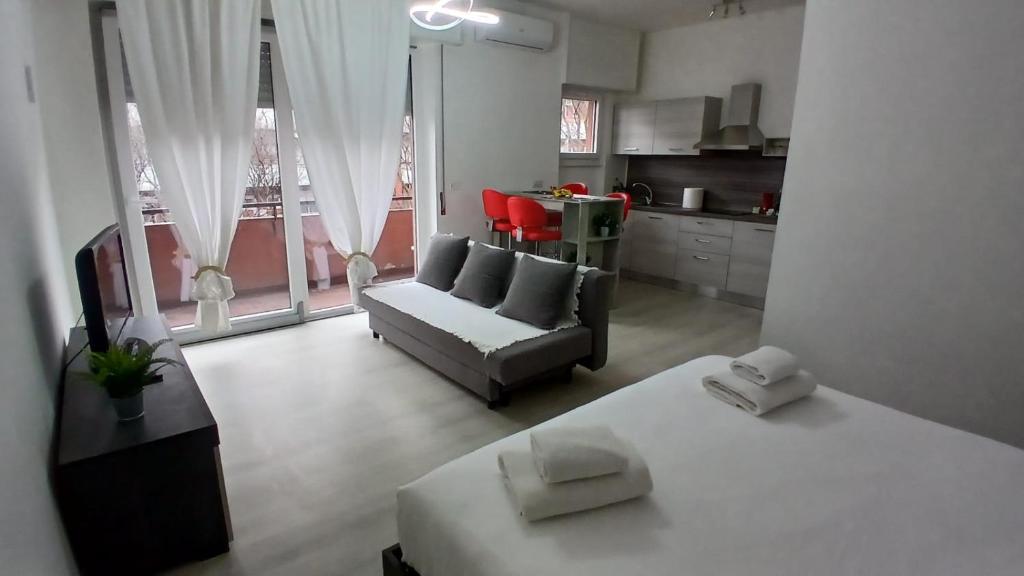 a living room with a bed and a couch and a kitchen at MilanoValery3 in Milan
