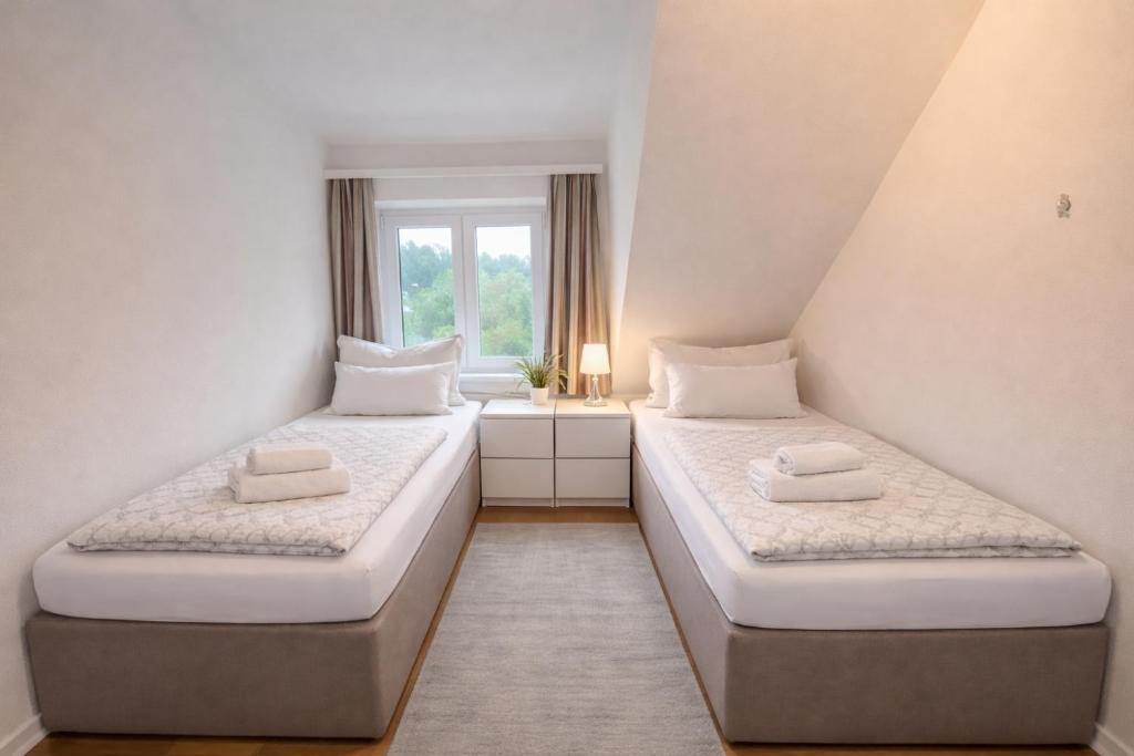 two beds in a room with a window at Zimmer & Apartments Wolfsberg C2 in Wolfsberg