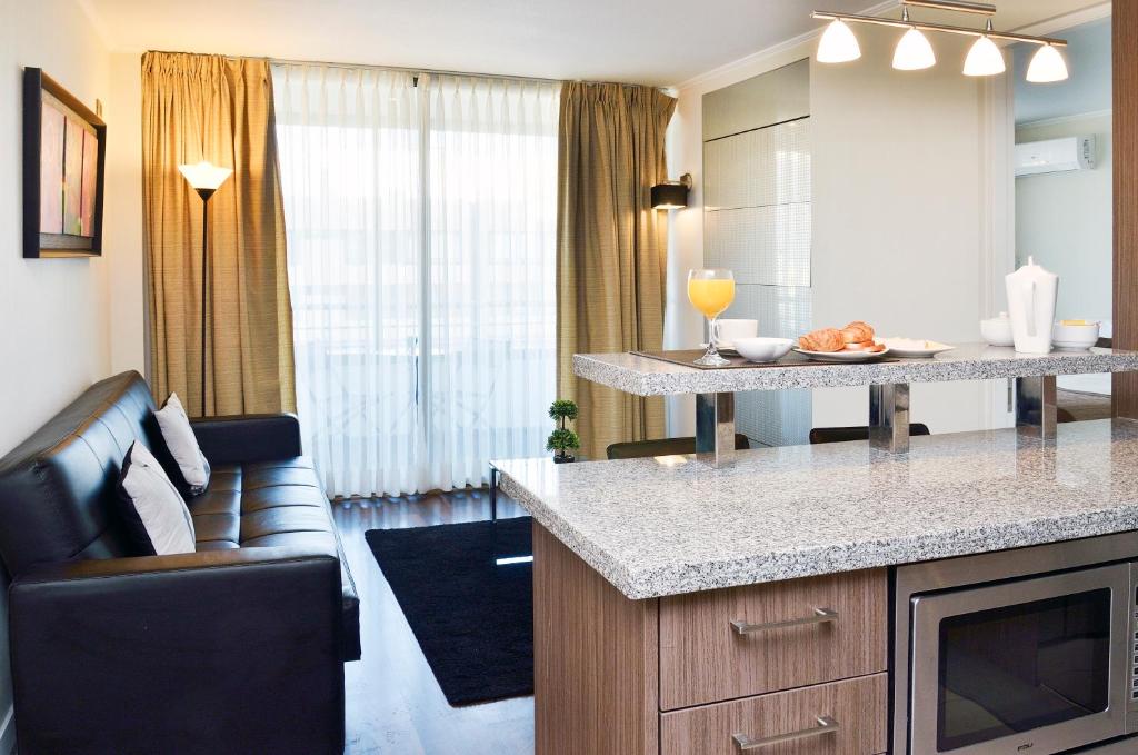 a kitchen and living room with a counter and a couch at Norus Las Condes in Santiago