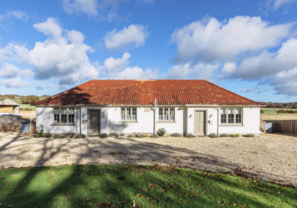a small white house with an orange roof at Dumbarnie East Cottage in Kirkton of Largo