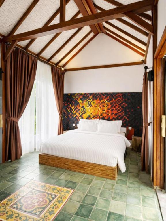 a bedroom with a large white bed in a room at Maza Lodge & Spa in Kejajar