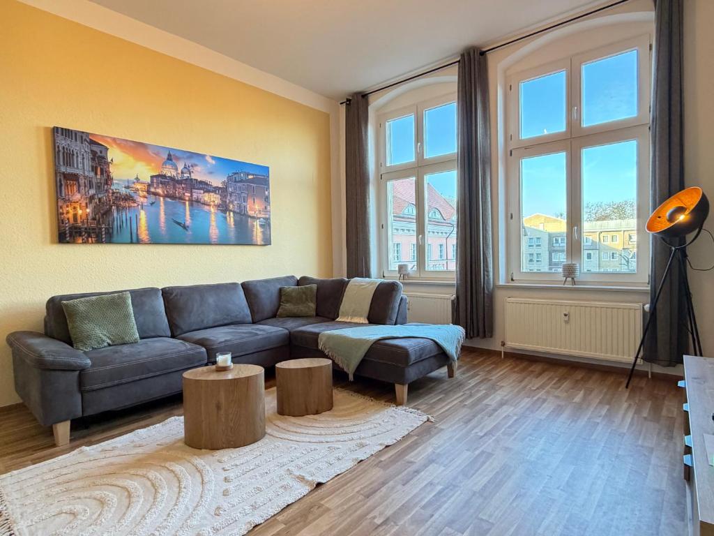 a living room with a couch and some windows at Ferienwohnung am Altmarkt, für bis zu 4 Personen, 55qm in Cottbus