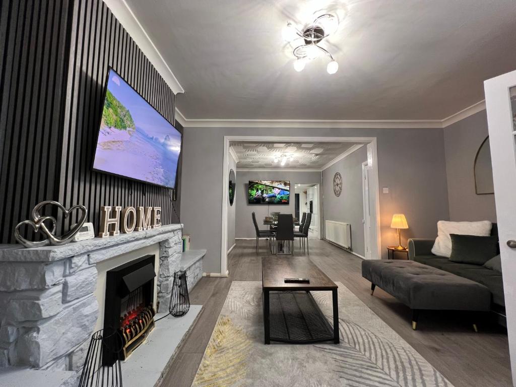 a living room with a fireplace and a tv at Victoria Maidstone Tranquil Retreat in Maidstone
