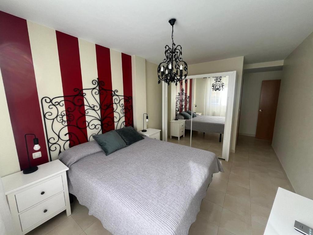 a bedroom with a bed with a red and white striped wall at Apartamento Senda in Comillas
