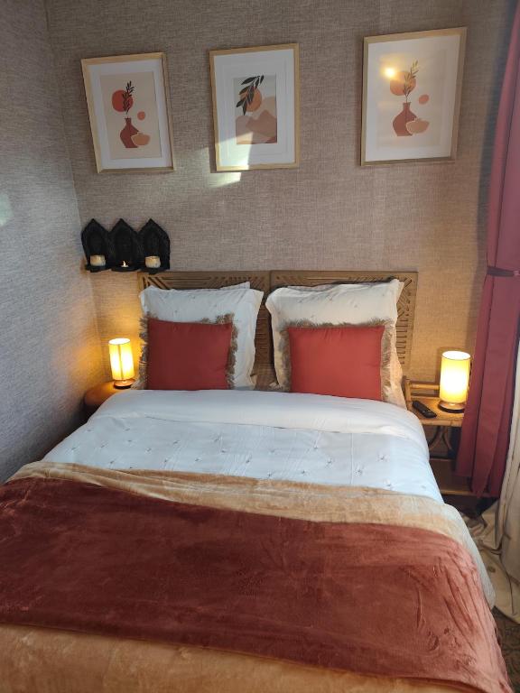 a bedroom with a large bed with red pillows at Villa Seven Petit Studio coin kitchenette in Dunkerque