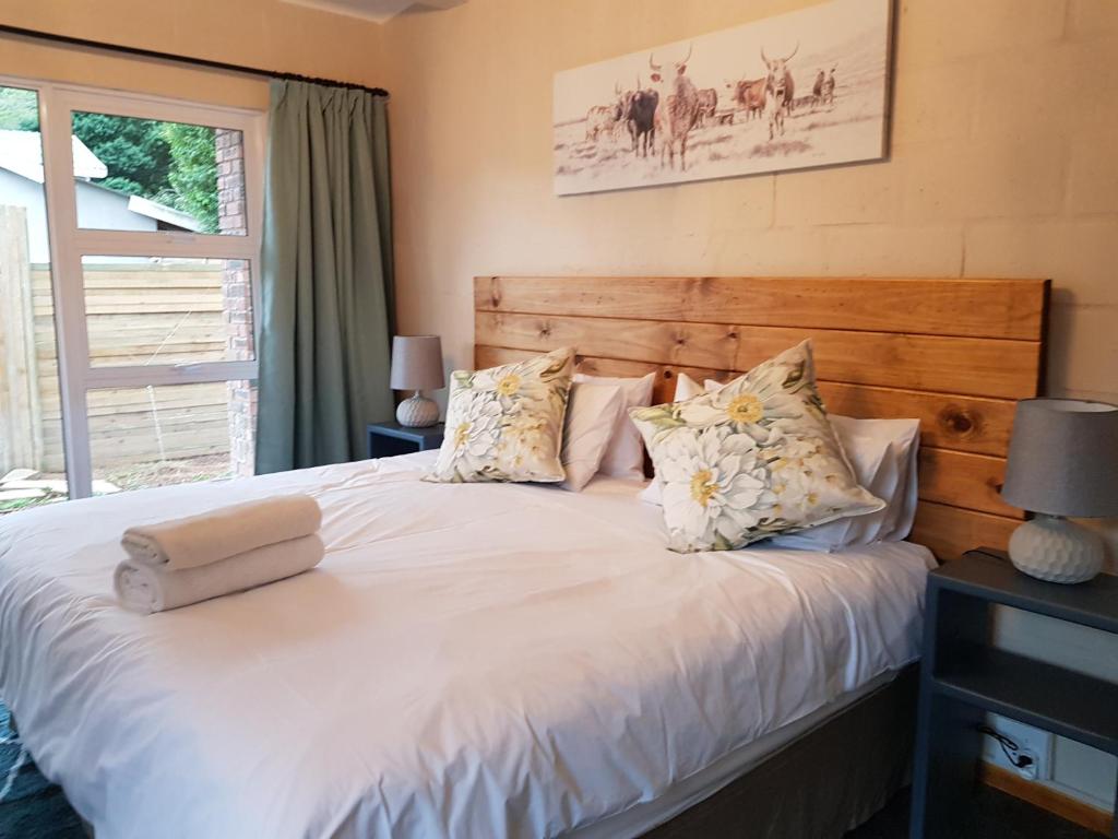 a bedroom with a bed with white sheets and pillows at Coach House Bed and Breakfast in Greytown