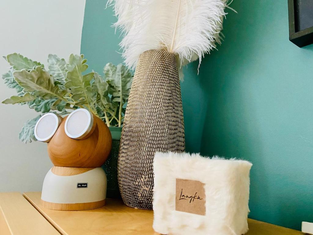 a table with two vases and a pillow and a feather at Studio face au château de Thy in Thy-le-Château