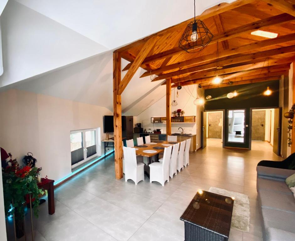 a dining room and living room with a table and chairs at Apartament 12-osobowy z gorącą balią, klimatyzowany in Oboźna Droga Masłów