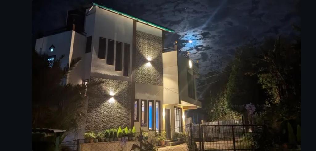 a house with lights on the side of it at night at GRETZbnb in Shillong