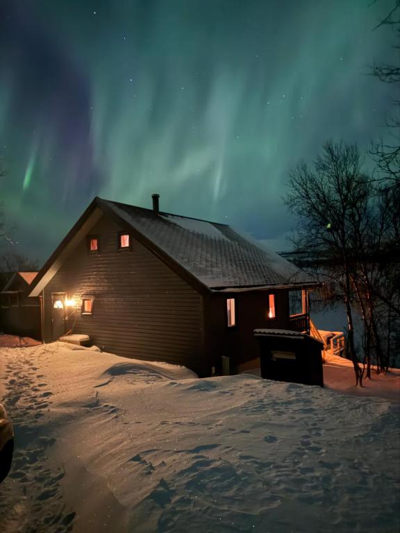a barn in the snow at night at Camp Oinas in Hammerfest
