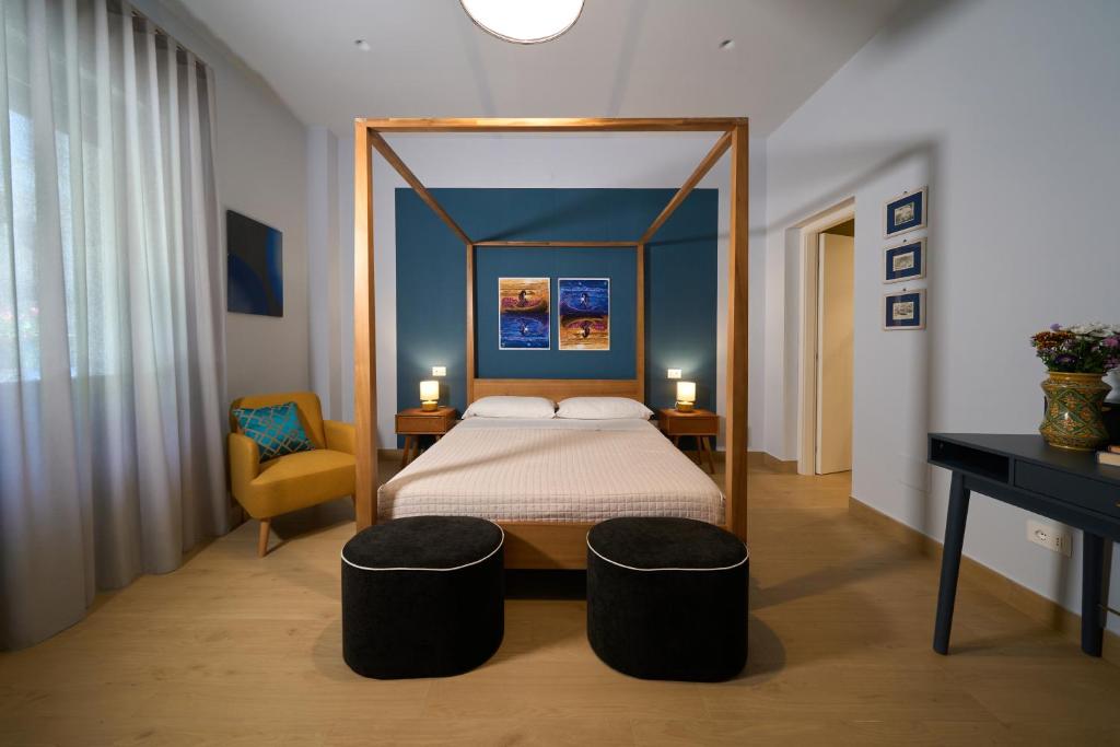 a bedroom with a canopy bed and a desk at Merlino Urban Suites in Messina