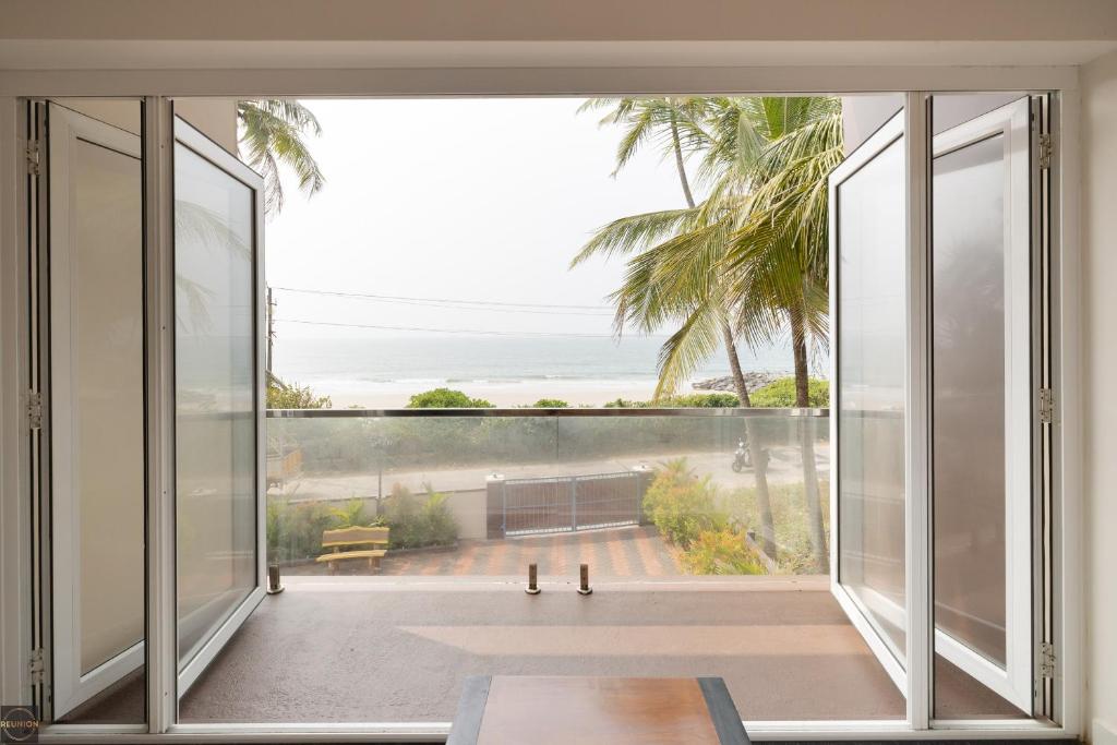 a room with a large window with a view of the ocean at Reunion Ocean Hridayam - Beach House in Udupi