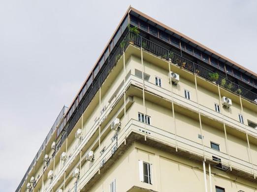 a large white building with plants on the top of it at Kara Guest House AA1 in Batam Center