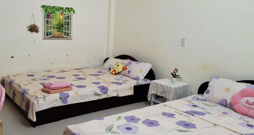 a bedroom with two beds and a small table at Lucky Minh An in Nha Trang