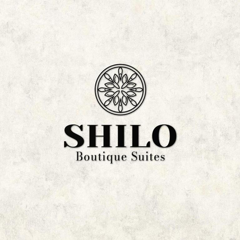 a logo for a boutiqueasteryasteryasteryasteryasteryasteryasteryasteryasteryasteryastery at Shilo Boutiqe Suites in Mishmār Hāyardin