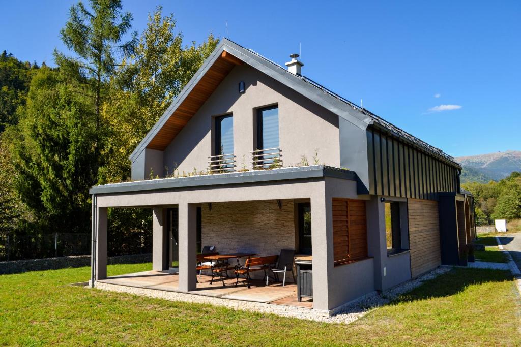 a detached house with a deck and a table at Chata Zingoty in Mýto pod Ďumbierom