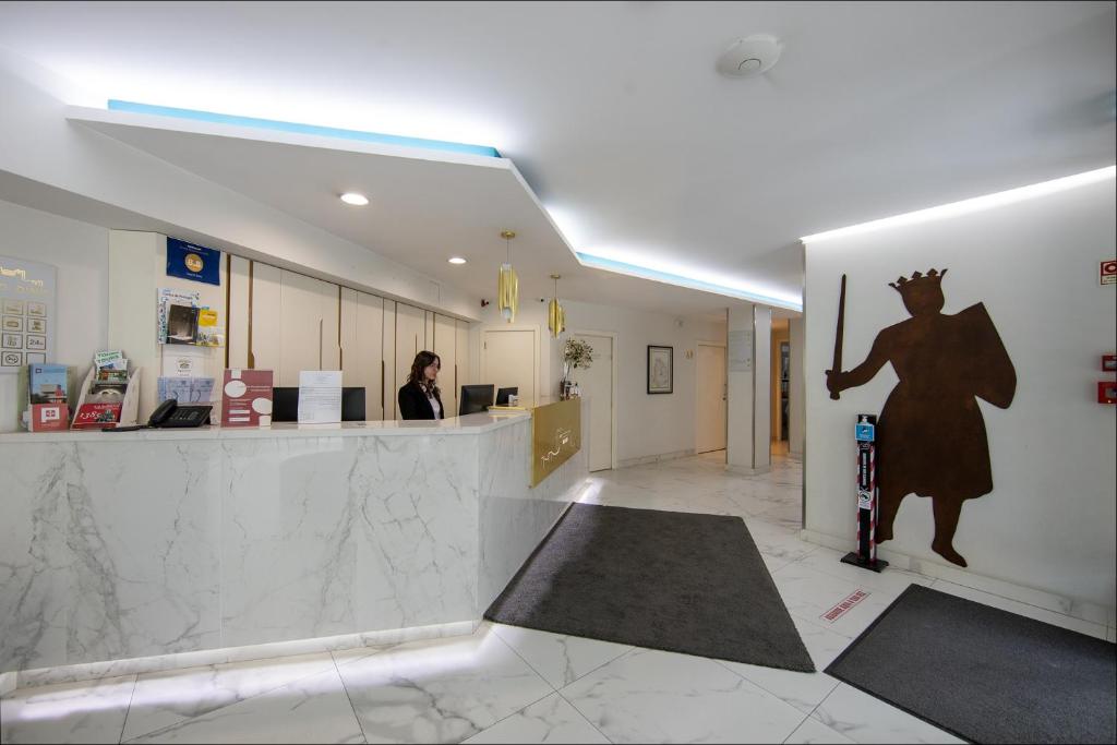 a woman standing at a counter in a building at Hotel D. Dinis in Leiria