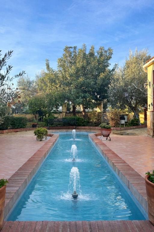 a fountain in the middle of a pool at Hotel Trajano in Zalamea de la Serena