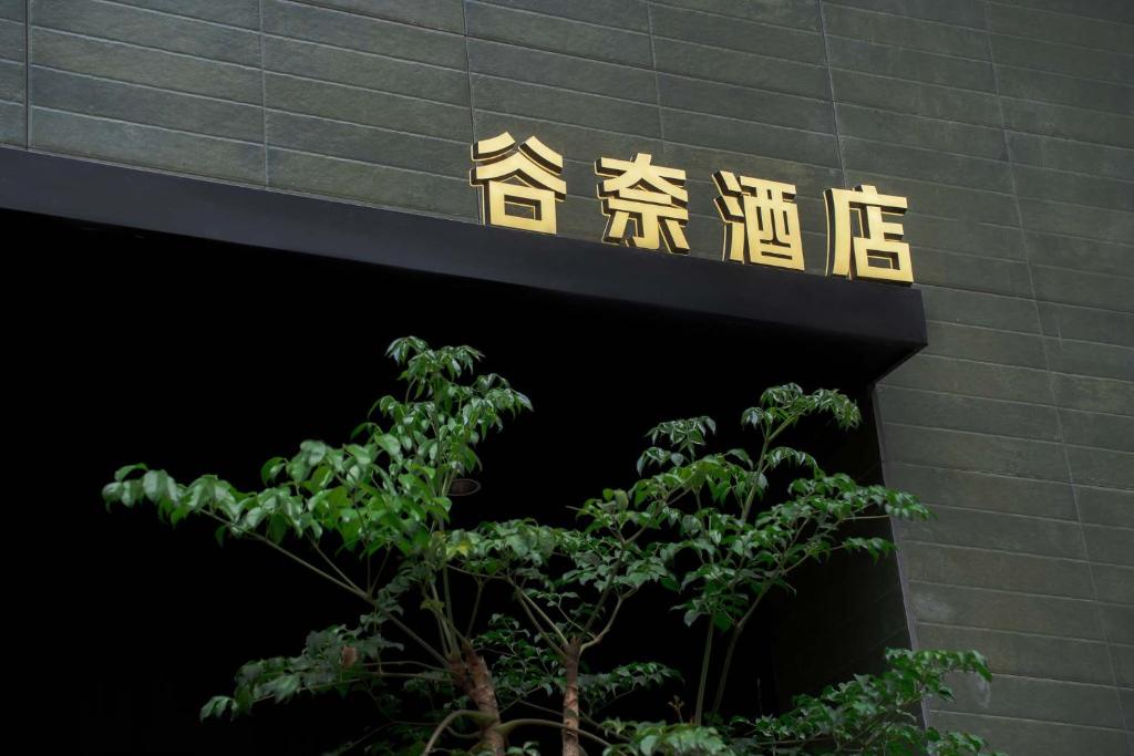 a sign on the side of a building with a tree at Good Night Hotel in Zhangjiajie