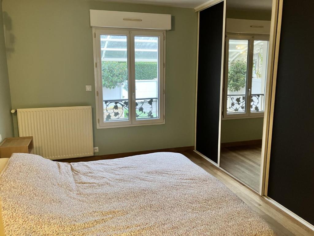 a bedroom with a bed and a large mirror at La Pause Normande - Bed & Breakfast in Bayeux