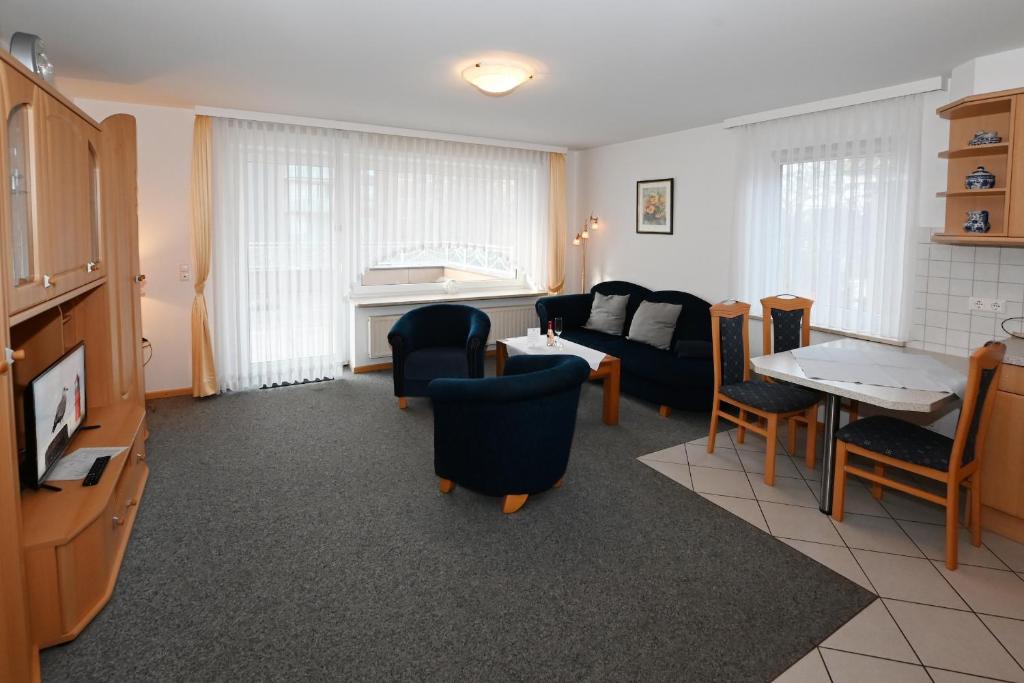 a living room with a couch and a table and chairs at Bernstein Mare-Supreme Wohnung 4 in Büsum