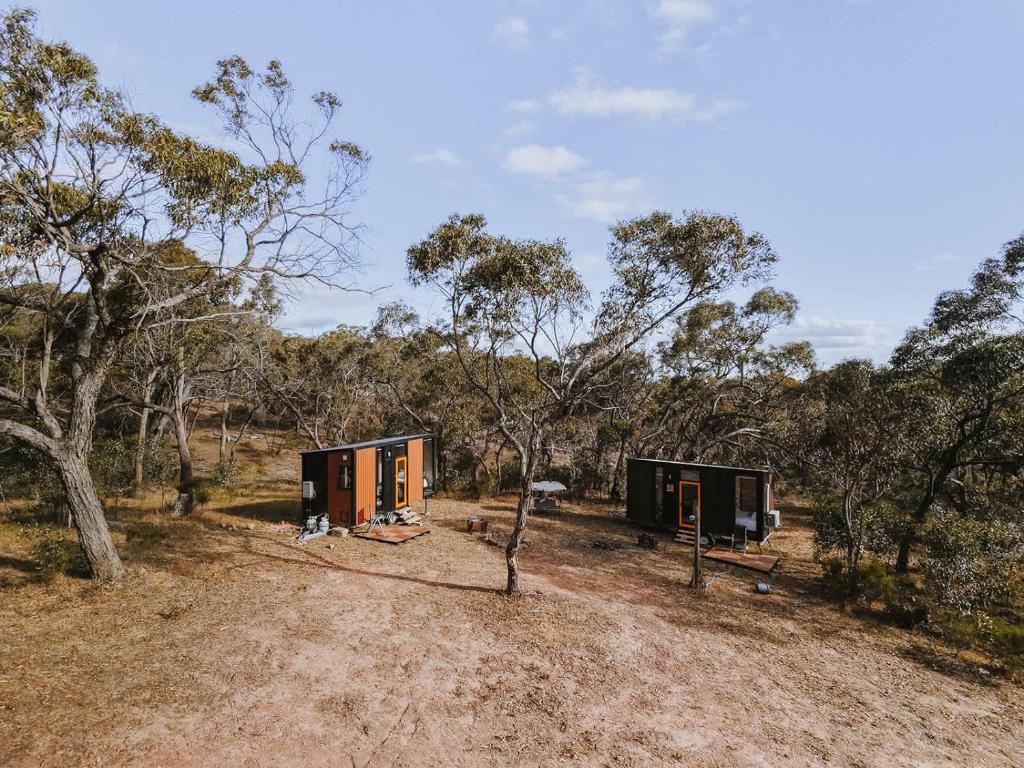 two shipping containers in the middle of a forest at Pigeon Pair Tiny Houses by Tiny Away in Tallarook