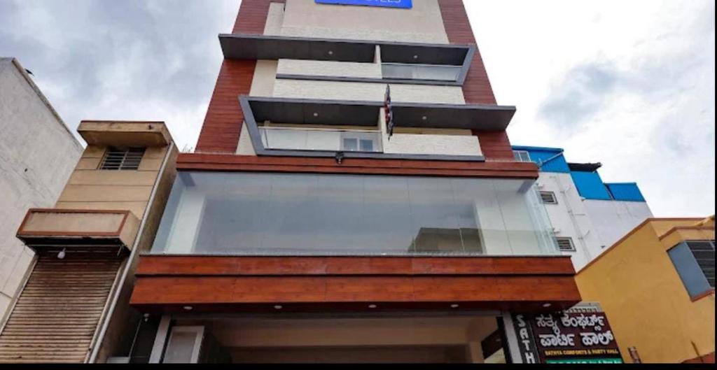 a tall building with glass windows on the side of it at Sathya Comforts in Bangalore