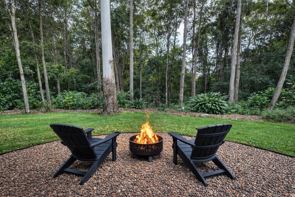 two chairs and a fire pit in a yard at Private Rainforest Guesthouse in Doonan in Doonan