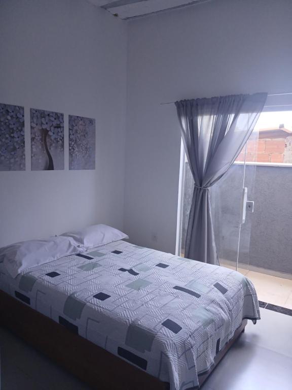 a bedroom with a bed and a window at Kitinete encantadora in Arraial do Cabo