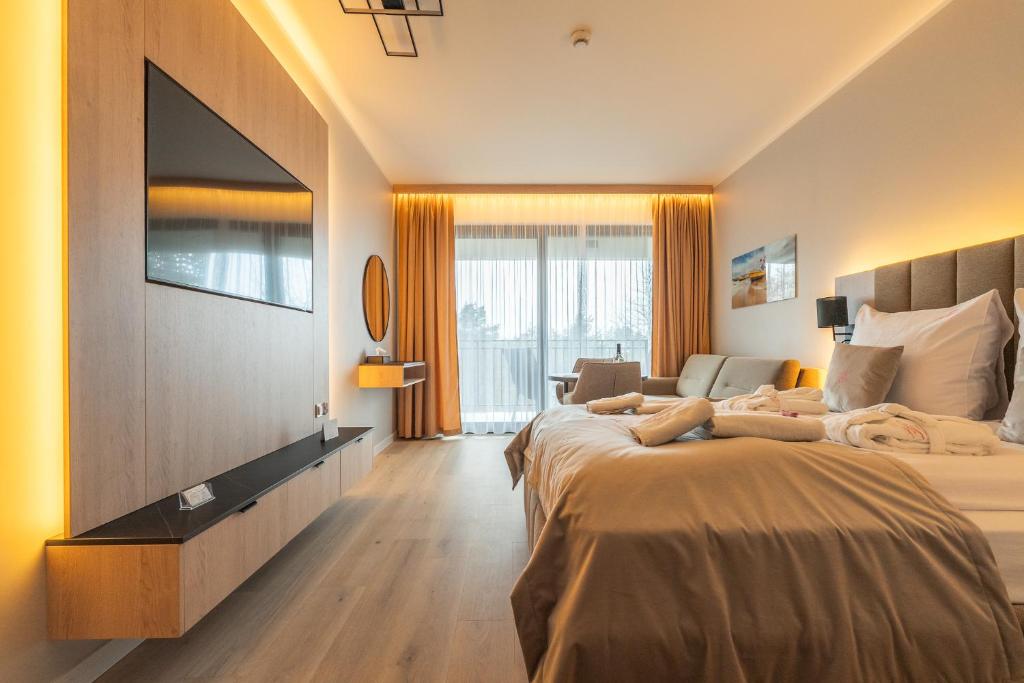 a hotel room with two beds and a flat screen tv at Your Holidays Infinity A233 in Międzyzdroje
