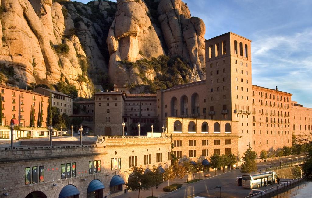 a large building with a mountain in the background at Hotel Abat Cisneros Montserrat in Montserrat