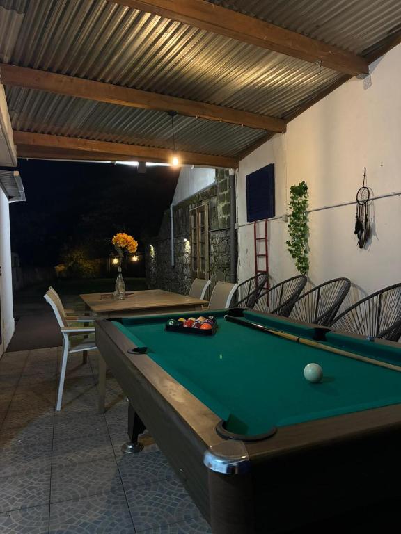 a pool table on a patio with chairs and awning at H2Furnas Natur in Furnas