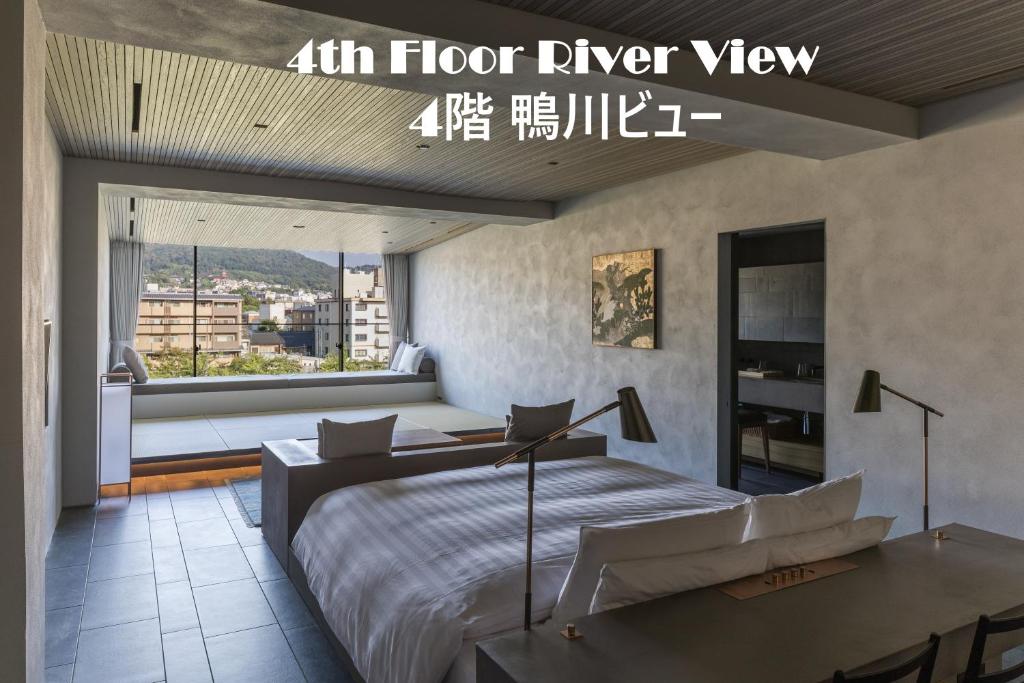 a bedroom with a king sized bed and a large window at Shizuru 鴨川 ""旧SGR鴨川"" in Kyoto