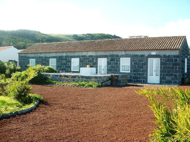 una casa de piedra con un gran patio delante en Quinta da Abegoaria en Abegoaria