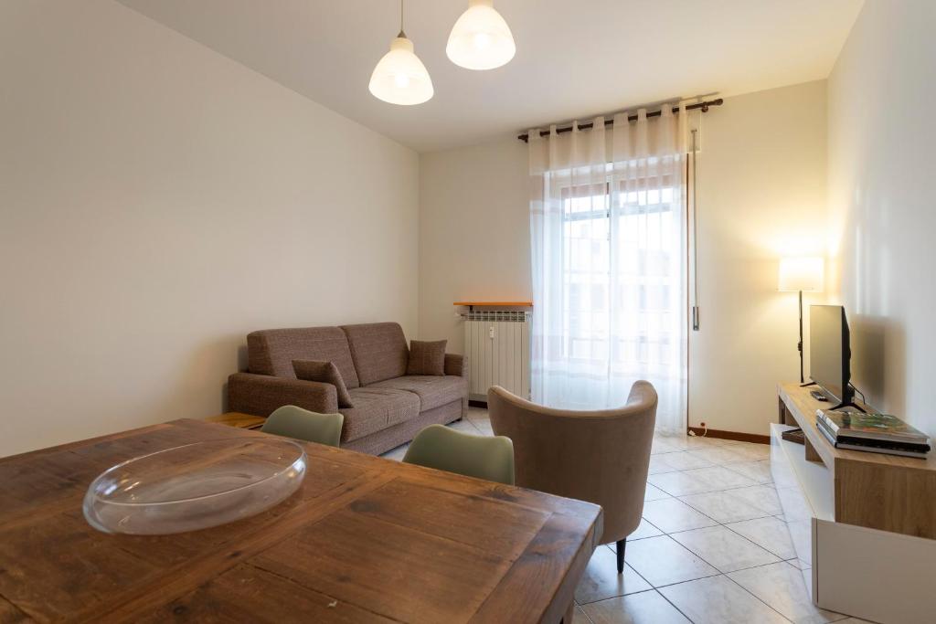 a living room with a table and a couch at Bicocca Urban Suite - SELF CHECKIN WIFI in Novara
