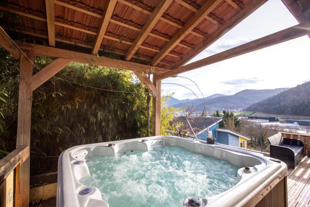 a hot tub on the deck of a house at Le Chalet Panoramique Jaccuzi Parking Vue Montagne in Munster