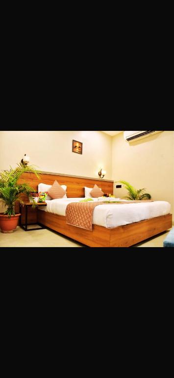 a bedroom with two beds and two potted plants at Ramaland in Faizābād