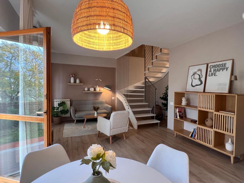 a living room with a table and a staircase at Chianti's Secret Nest - Cozy home with sunset view in Impruneta