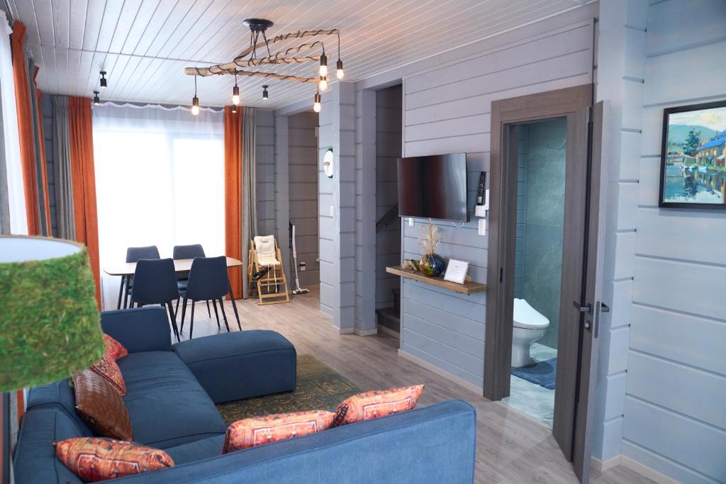 a living room with a blue couch and a kitchen at MATRYOSHKA HOUSE 2nd GUEST HOUSE in Yoichi