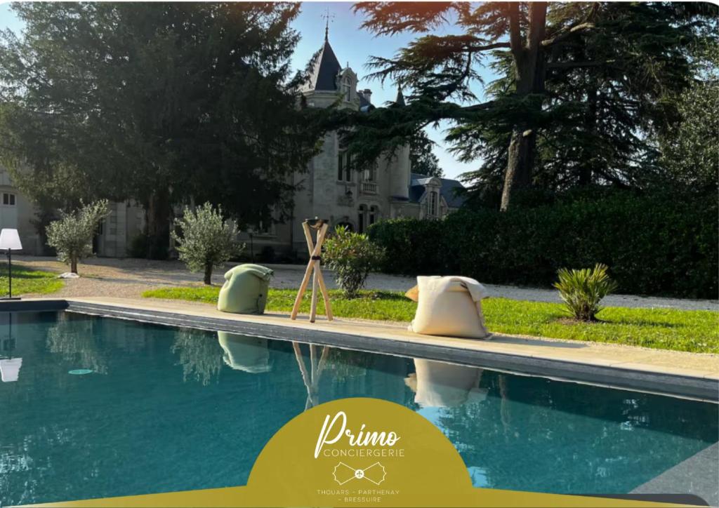 a swimming pool with a house in the background at Studio Charmant au Château Leugny in La Celle-sous-Gouzon
