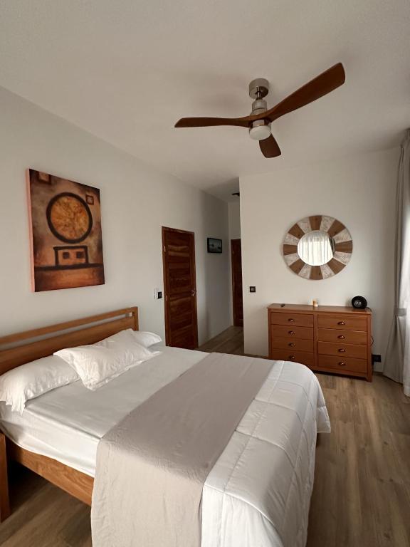 a bedroom with a bed and a ceiling fan at Green Heaven Studio in Bois Chéri